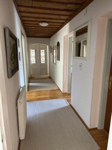 a hallway of a home with white walls and a wooden ceiling at Ferienwohnung Christine am Weissenbach in Strobl