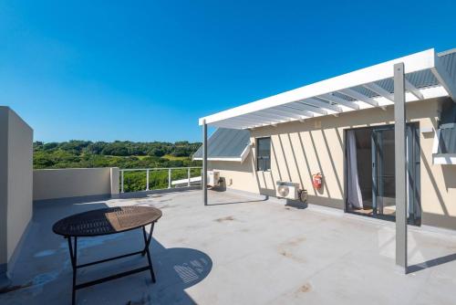 a patio with a table and a building at Refined 3 Bedroom Apartment Princes Grant in Blythedale