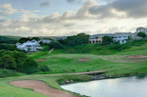 a view of a golf course with a body of water at Refined 3 Bedroom Apartment Princes Grant in Blythedale