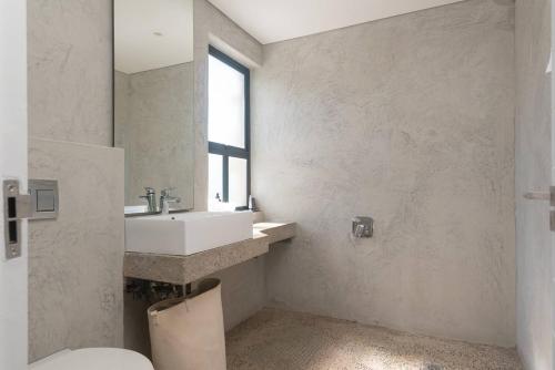a bathroom with a sink and a toilet and a window at Refined 3 Bedroom Apartment Princes Grant in Blythedale