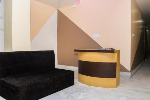 a lobby with a black chair and a table at OYO Hotel Sonar Gaon in Agartala