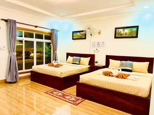 森莫諾隆的住宿－Chomkatae Bungalows，一间卧室设有两张床和窗户。