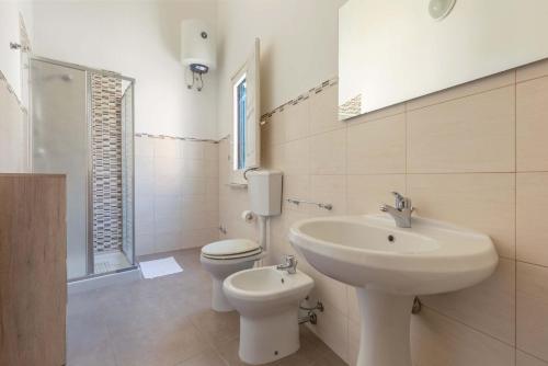 Baño blanco con lavabo y aseo en Dimora La Torre by BarbarHouse en Leverano