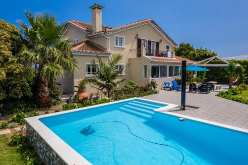 a villa with a swimming pool in front of a house at Quinta das Hortências in São Vicente Ferreira