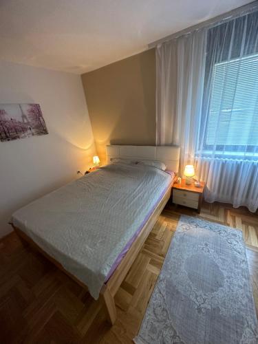 a bedroom with a bed and a large window at Perla stan Breka in Sarajevo