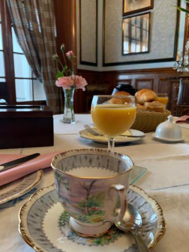 - une table avec une tasse de café et un verre de jus d'orange dans l'établissement Manoir Sainte Cecile Art Nouveau, à Juvigny-sous-Andaine