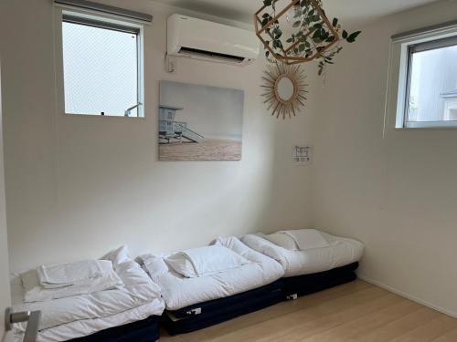 a living room with a couch in the corner of a room at trive osu east 最大7名宿泊可能 in Nagoya