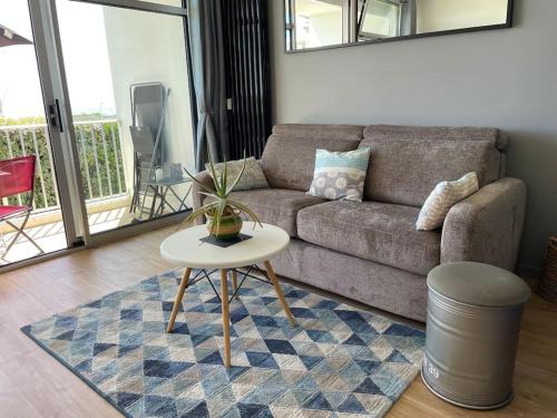 a living room with a couch and a table at Appartement Belles Vacances in Quiberon