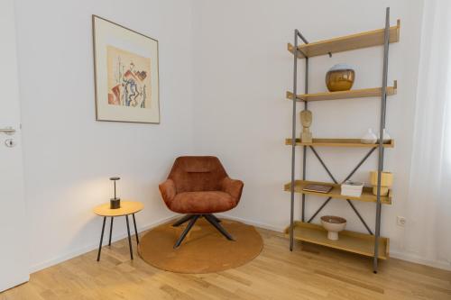 a room with a chair and a table and shelves at LaMiaCasa City-Grande Family-Business Groups in Stuttgart
