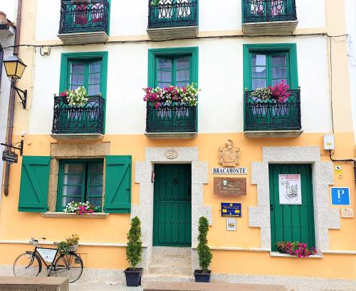 a facade of a building with green doors and balconies at Casa Bracamonte in Mondoñedo