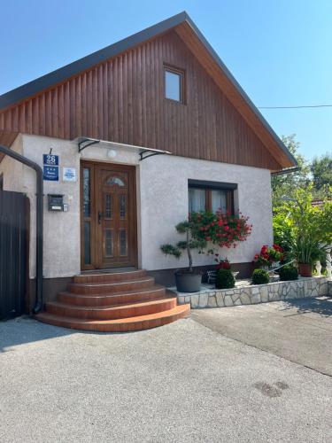 a building with a wooden door and stairs in front at Apartman Anna in Ogulin