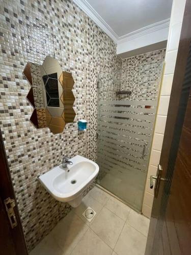 y baño con lavabo y ducha. en apartment 60m 1bedroom for rent3 en Umm Uthainah
