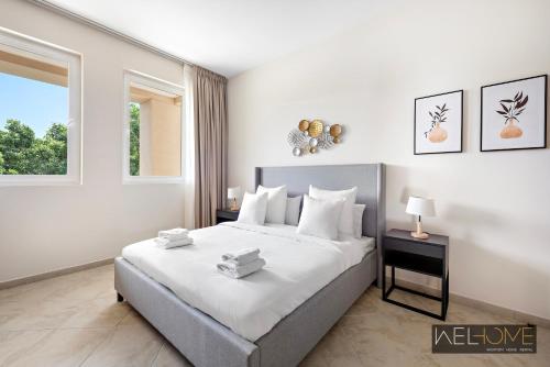 a bedroom with a large bed and a window at WelHome - Prime Apartment With Balcony Amidst Lively Area in Dubai