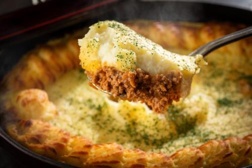 a spoon with a piece of food in a casserole dish at Art Hotel Narita in Narita