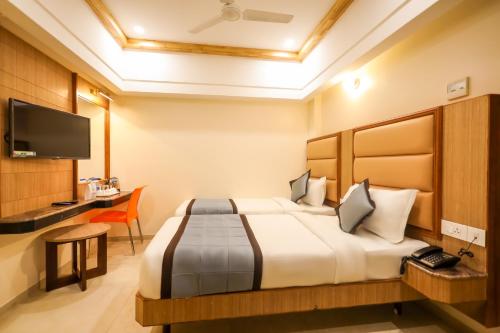um quarto de hotel com uma cama e uma secretária em Hotel Grand Sabarees em Madurai