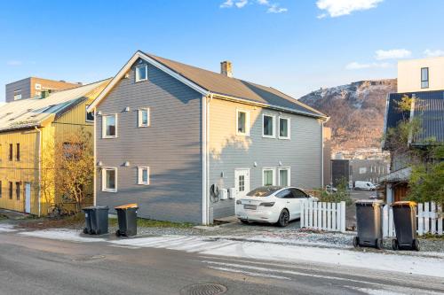 una casa con un coche aparcado delante de ella en Luxury apartement close to city centre with free parking, en Tromsø
