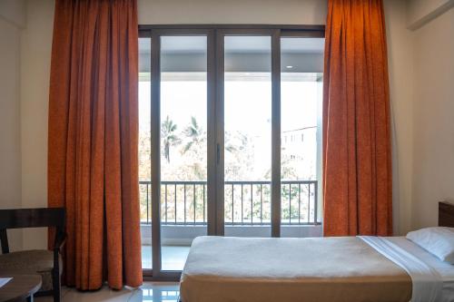 a bedroom with a bed and a large window at Hotel Dreamland in Pune