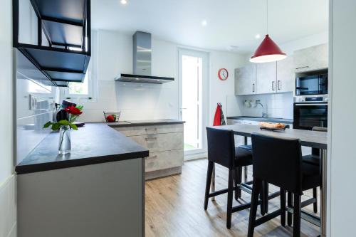 une cuisine avec un grand îlot et des tabourets de bar dans l'établissement Appartement convivial proche centre - Terrasse & Parking privé gratuit, à Avignon