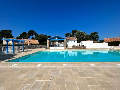 une grande piscine avec un ciel bleu clair dans l'établissement L'évasion des pins - Au coeur de la Nature, à Saint-Jean-de-Monts