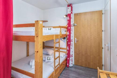- deux lits superposés dans une chambre avec une porte dans l'établissement Charmant studio + jardin vue pistes et local velo, à Praz-sur-Arly