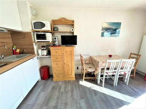 une cuisine avec une table et une cuisine avec une table et des chaises dans l'établissement Charmant studio + jardin vue pistes et local velo, à Praz-sur-Arly