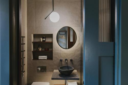 La salle de bains est pourvue d'un lavabo et d'un miroir. dans l'établissement Albergo Miramonti, à Corteno Golgi