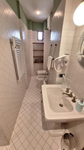 een witte badkamer met een wastafel en 2 toiletten bij Casa Mojito in Florence