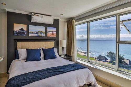a bedroom with a large bed and a large window at Nautical views in Mossel Bay