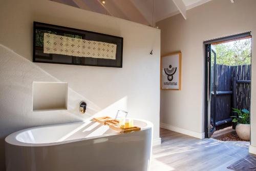 a bath tub in a room with a window at Moya Safari Villa in Hoedspruit