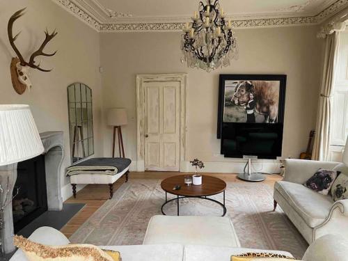 a living room with a couch and a tv at Home of Joy - 3 bedroom home with private garden in Glasgow
