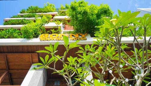 een gebouw met planten en een bord erop bij Bonny Boutique Hotel Da Nang in Da Nang