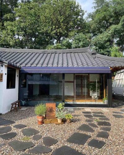 een huis met een paars dak en een aantal planten bij Bow Hanok House in Gangneung