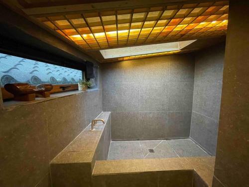 a bathroom with a shower with a bench in it at Bow Hanok House in Gangneung