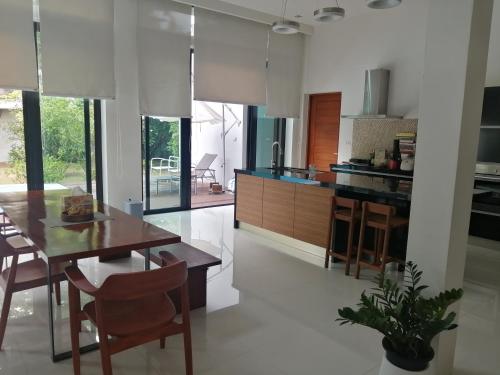 a kitchen with a wooden table and a dining room at AP HOUSE in Bangkok