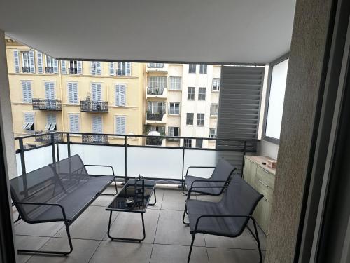 d'un balcon avec des chaises et une table offrant une vue sur un bâtiment. dans l'établissement Superbe Appartement terrasse 2P à 5 min à pied du vieux Nice, du port et du Tram, à Nice