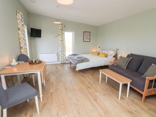 a living room with a couch and a table at The Wheelhouse in Carinish