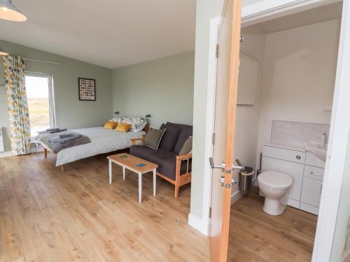 a living room with a couch and a table at The Wheelhouse in Carinish