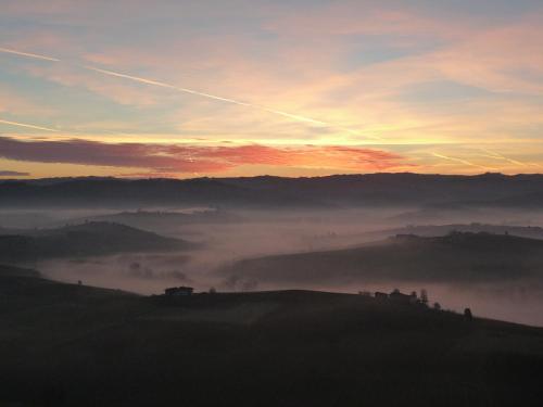 a view of a foggy valley with the sun setting at La Vigna Del Parroco in Verduno