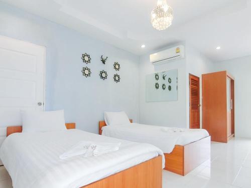 a white room with two beds and a chandelier at AURA Park Resort in Ban Thung Sam Sao