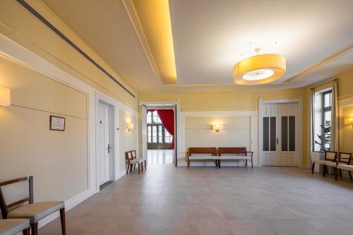 a large room with chairs and a ceiling at Erzsébet Királyné Szálloda in Gödöllő