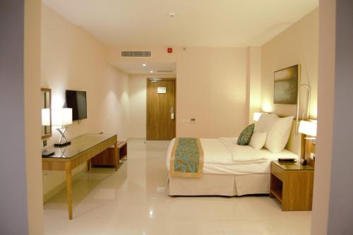 a hotel room with a bed and a desk at Best Western Plus Buraidah in Buraydah