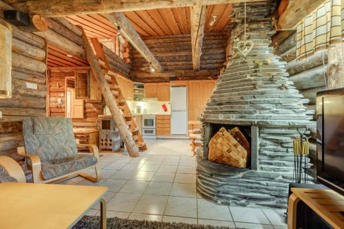 ein Wohnzimmer mit einem Steinkamin in einer Blockhütte in der Unterkunft Kelohonkahuoneisto Käkriäinen B in Kemijärvi