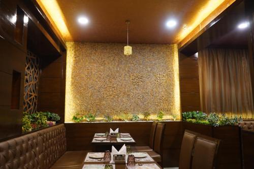 a restaurant with two tables and a stone wall at THE KALINGA INN in Rohtak