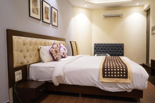 a bedroom with a large bed with white sheets and pillows at THE KALINGA INN in Rohtak