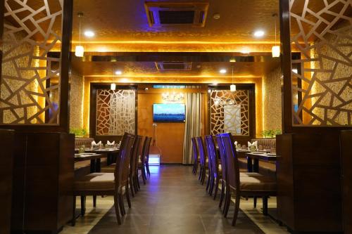 a restaurant with tables and chairs in a room at THE KALINGA INN in Rohtak