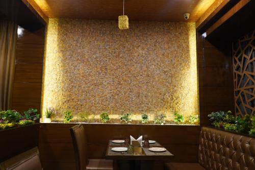 a dining room with a table and a brick wall at THE KALINGA INN in Rohtak