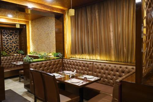 a restaurant with a long table and chairs at THE KALINGA INN in Rohtak