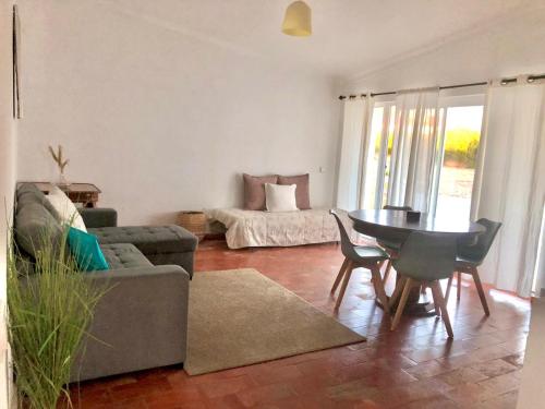 a living room with a couch and a table and chairs at Casa da praia in Aljezur