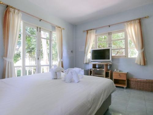 - une chambre avec un grand lit blanc et des serviettes dans l'établissement AURA Park Resort, à Ban Thung Sam Sao