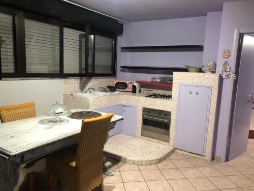 uma cozinha com uma mesa e um fogão forno superior em Suite Viola@ em Legnano